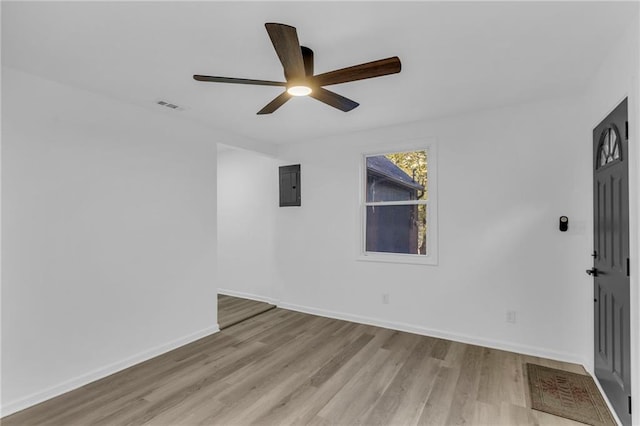 spare room featuring light wood-type flooring, electric panel, and ceiling fan