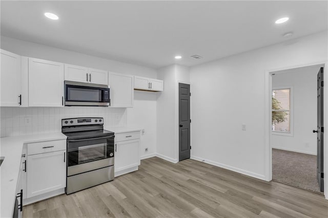 kitchen with white cabinetry, appliances with stainless steel finishes, decorative backsplash, and light hardwood / wood-style floors