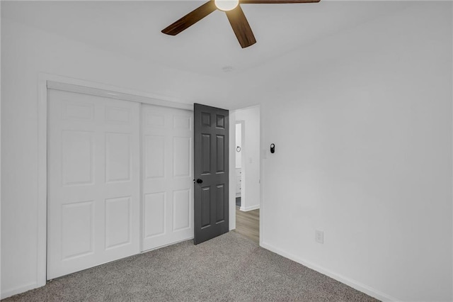 unfurnished bedroom with ceiling fan, a closet, and light colored carpet