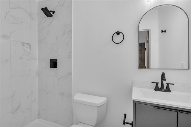 bathroom with vanity, toilet, and tiled shower