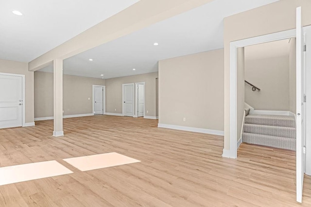 interior space featuring recessed lighting, baseboards, light wood-style floors, and stairs