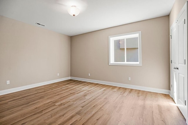 unfurnished room featuring light wood-style flooring, baseboards, and visible vents