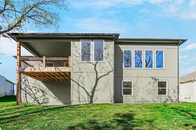 rear view of property with a wooden deck and a yard