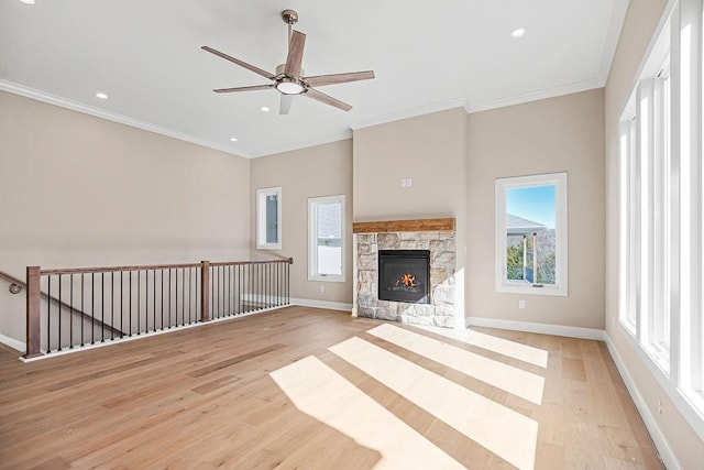 unfurnished living room with light wood finished floors, baseboards, ornamental molding, recessed lighting, and a fireplace