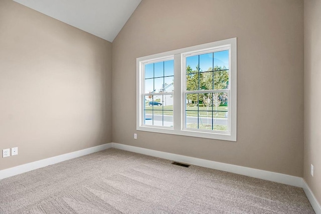 unfurnished room featuring visible vents, baseboards, lofted ceiling, and carpet