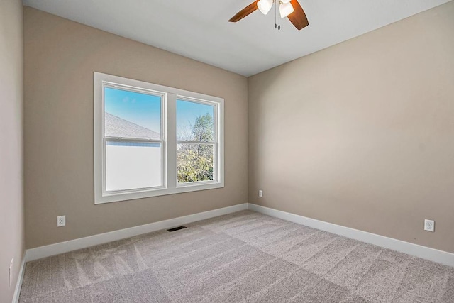 carpeted empty room with a ceiling fan, baseboards, and visible vents