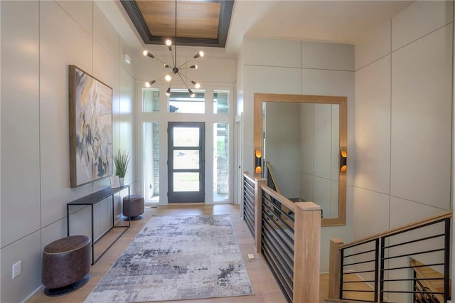 entryway featuring a tray ceiling, tile walls, and ornamental molding