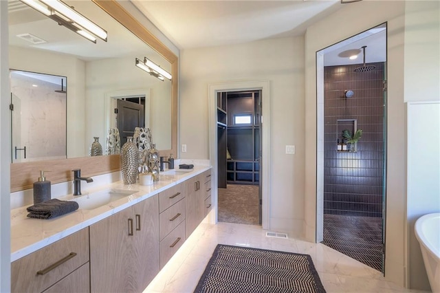 bathroom featuring tile patterned floors, vanity, and tiled shower