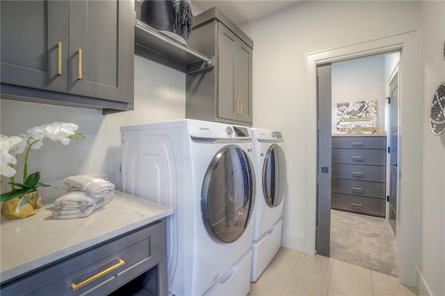 laundry room with separate washer and dryer, light colored carpet, and cabinets