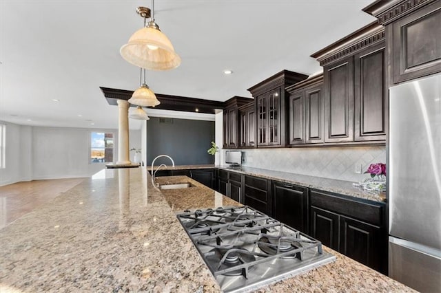 kitchen featuring sink, decorative light fixtures, ornate columns, appliances with stainless steel finishes, and dark brown cabinets