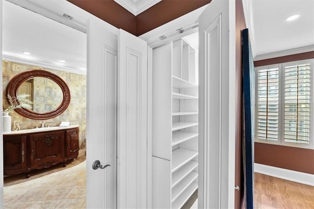 interior space with hardwood / wood-style floors, vanity, and crown molding