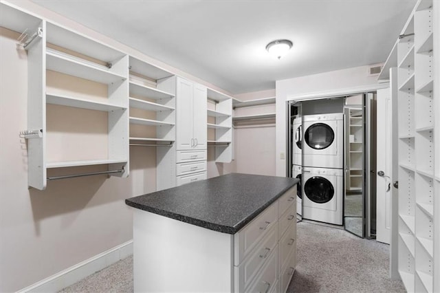 spacious closet featuring light carpet and stacked washer and dryer