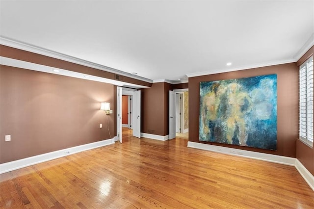 spare room featuring light wood-type flooring and ornamental molding