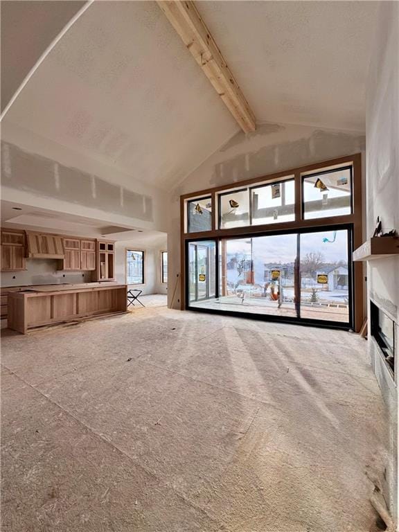 unfurnished living room featuring beamed ceiling, high vaulted ceiling, and light carpet