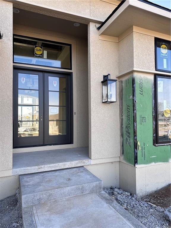 property entrance with french doors and stucco siding