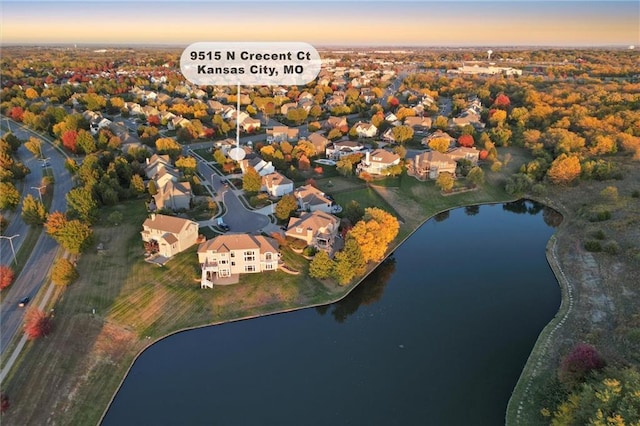 aerial view at dusk featuring a water view