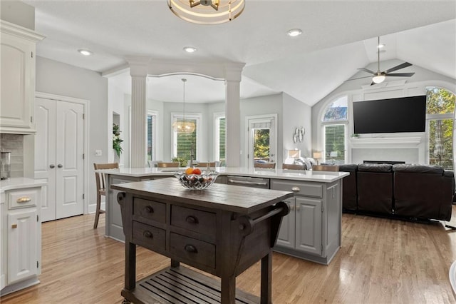 kitchen with butcher block counters, white cabinetry, a wealth of natural light, and ornate columns