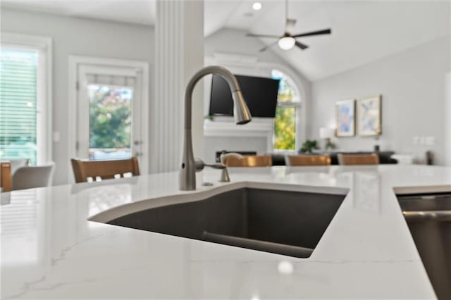 kitchen with sink, stainless steel dishwasher, vaulted ceiling, and ceiling fan