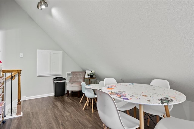 dining area with dark hardwood / wood-style flooring and vaulted ceiling