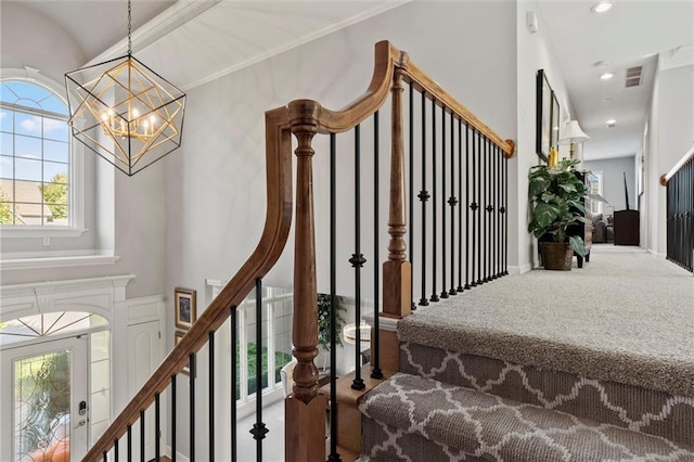 staircase with a chandelier and hardwood / wood-style floors