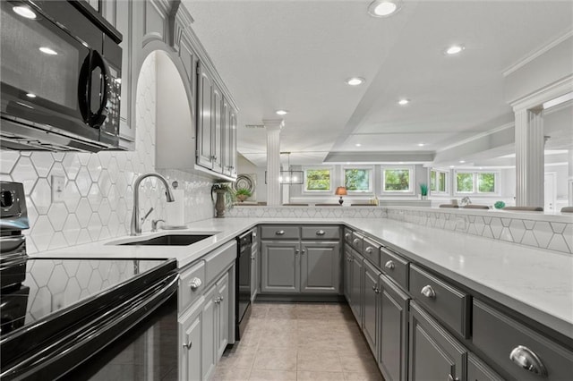 kitchen featuring black appliances, light stone counters, ornamental molding, gray cabinets, and sink