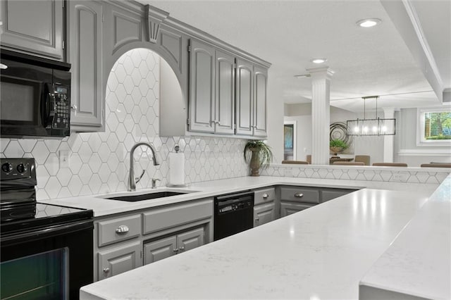 kitchen with gray cabinetry, ornate columns, black appliances, and sink