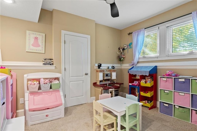 recreation room with light colored carpet and ceiling fan