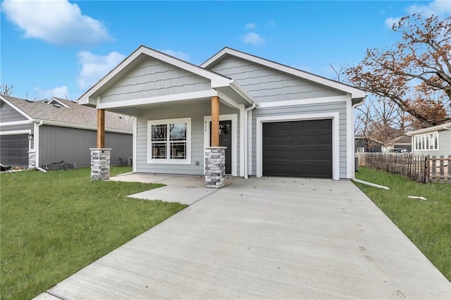 craftsman inspired home featuring covered porch, a garage, and a front yard