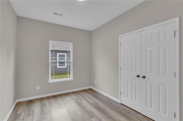 unfurnished bedroom featuring a closet and light hardwood / wood-style flooring