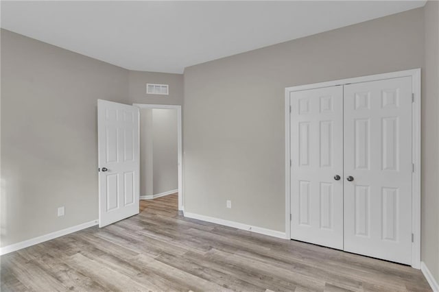 unfurnished bedroom featuring a closet and light hardwood / wood-style floors