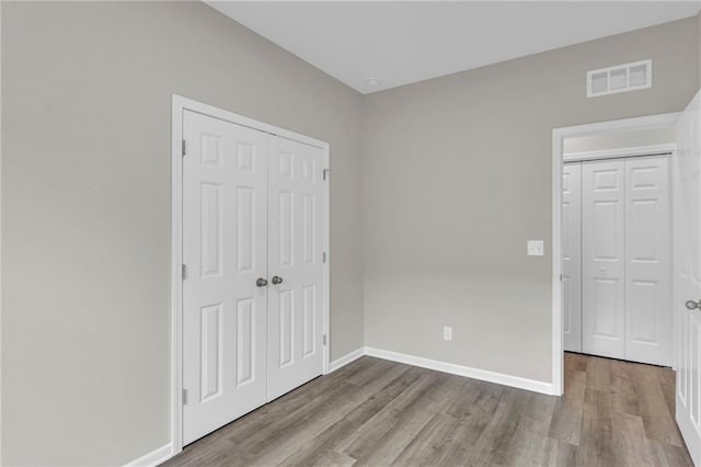 unfurnished bedroom featuring light hardwood / wood-style flooring and a closet