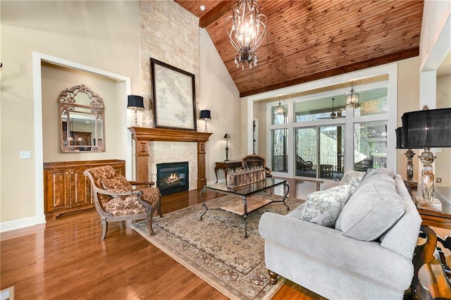 living room with a stone fireplace, high vaulted ceiling, hardwood / wood-style floors, a chandelier, and wood ceiling