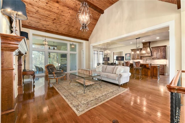 living room featuring dark wood-type flooring, high vaulted ceiling, wooden ceiling, and a notable chandelier