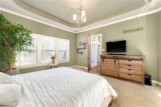 carpeted bedroom with a chandelier, a tray ceiling, and ornamental molding