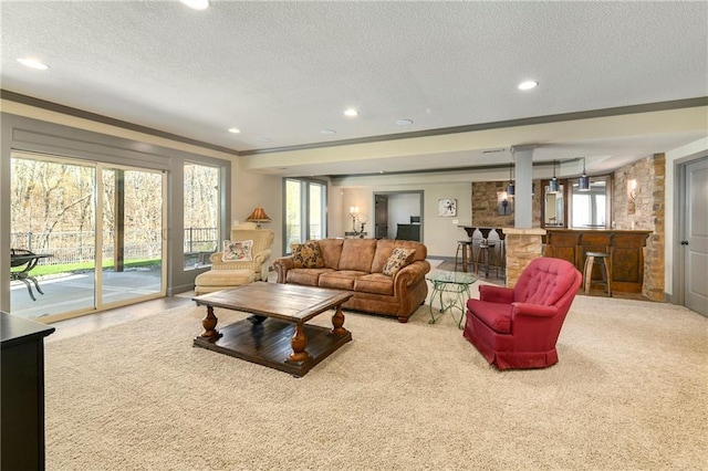 carpeted living room with bar area, a textured ceiling, and crown molding