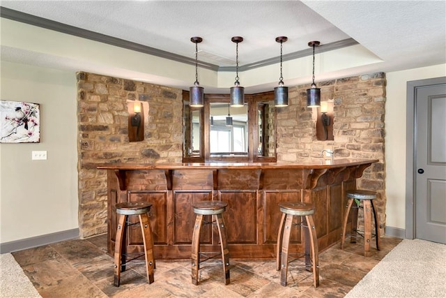 bar featuring a textured ceiling, decorative light fixtures, a raised ceiling, and ornamental molding