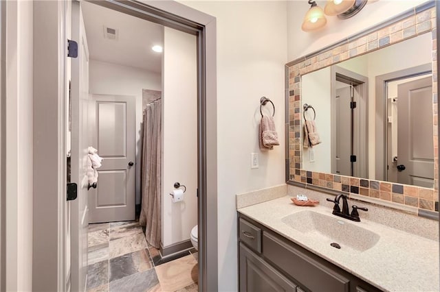 bathroom featuring curtained shower, vanity, and toilet