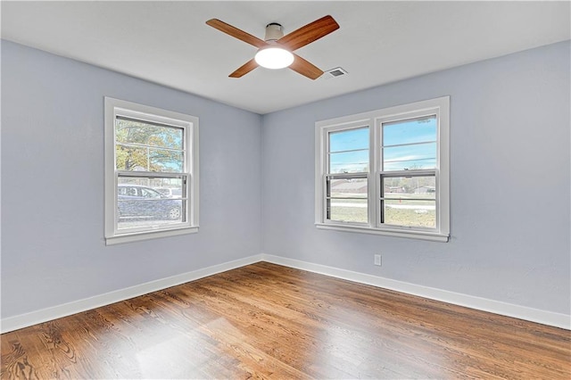 empty room with ceiling fan and hardwood / wood-style flooring