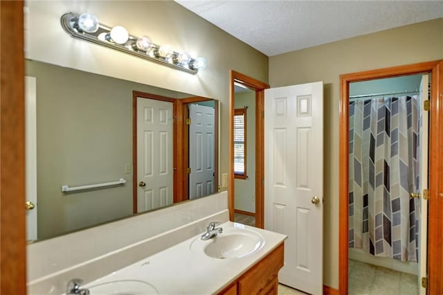 bathroom featuring tile patterned flooring, vanity, a textured ceiling, and walk in shower