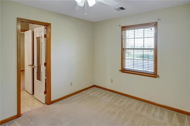 unfurnished room featuring light colored carpet and ceiling fan