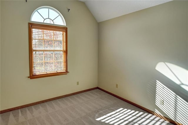 unfurnished room featuring light colored carpet and lofted ceiling