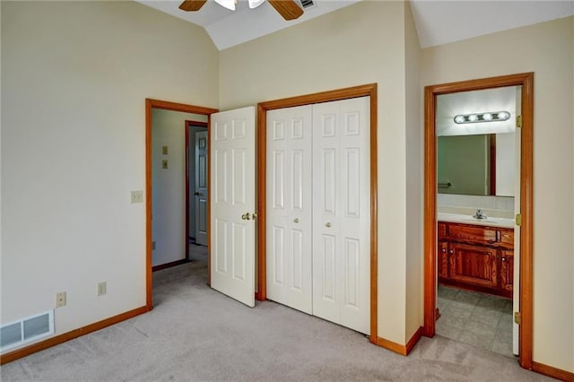 unfurnished bedroom featuring ensuite bathroom, ceiling fan, light colored carpet, and lofted ceiling