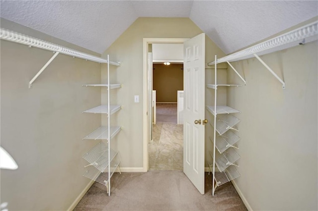 spacious closet featuring carpet flooring and vaulted ceiling