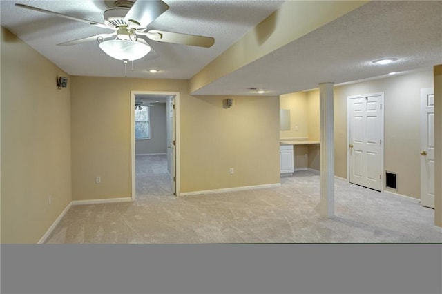 carpeted empty room with ceiling fan and a textured ceiling