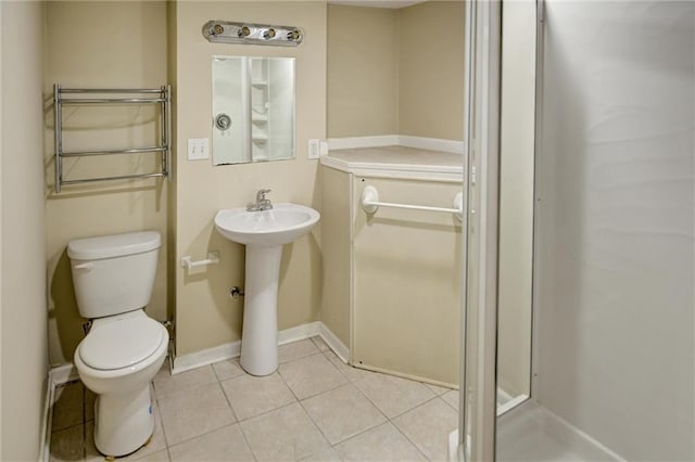 bathroom with tile patterned flooring, radiator heating unit, toilet, and sink