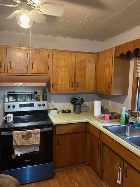 kitchen with light wood-type flooring, sink, ceiling fan, and electric range