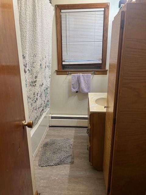 bathroom with shower / bath combo, vanity, and a baseboard radiator