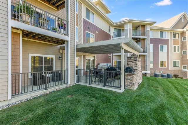 back of property with central AC unit, a patio, a balcony, and a yard