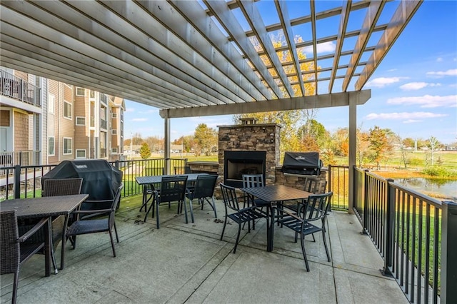 view of patio / terrace with area for grilling, a pergola, and an outdoor stone fireplace