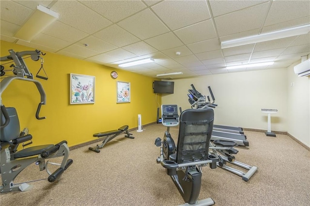 interior space with a wall unit AC, a paneled ceiling, and carpet floors